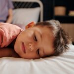 why is my child sleeping with eyes half open when sick
